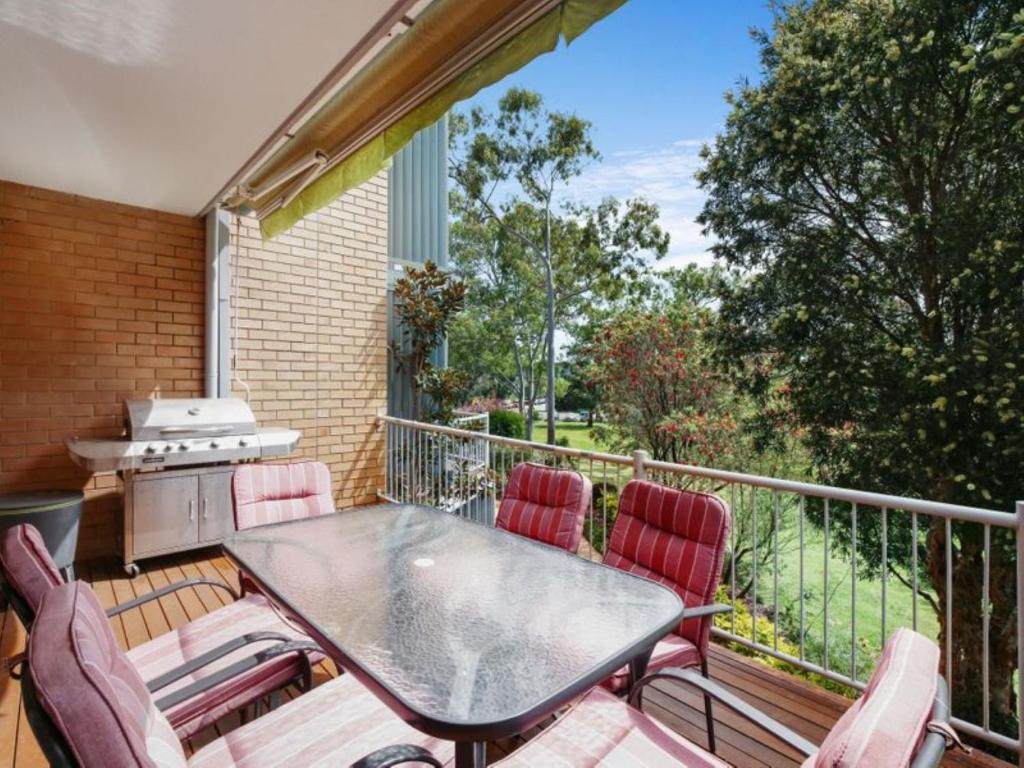 a patio with a table and chairs on a balcony at Greenpark #10 in Avoca Beach