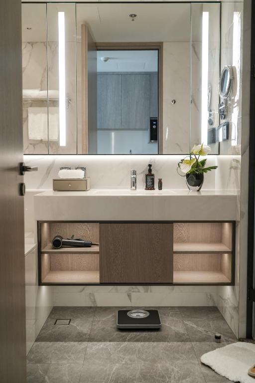 a bathroom with a sink and a mirror at Somerset QPlex Shenzhen in Shenzhen