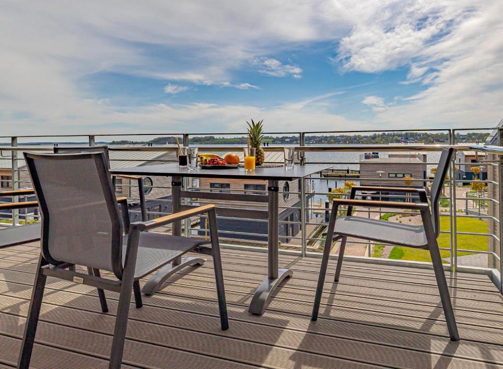 einen Balkon mit einem Tisch und Stühlen auf einem Schiff in der Unterkunft Ferienwohnung Wiking-Koje 5 Schleswig in Schleswig