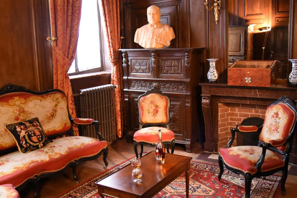 - un salon avec une statue d'un homme sur une cheminée dans l'établissement Château Hôtel de Warenghien, à Douai