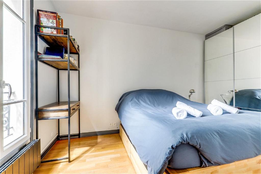 une chambre avec un lit et une étagère dans l'établissement Appartement exclusif au Parc Montsouris by Weekome, à Paris