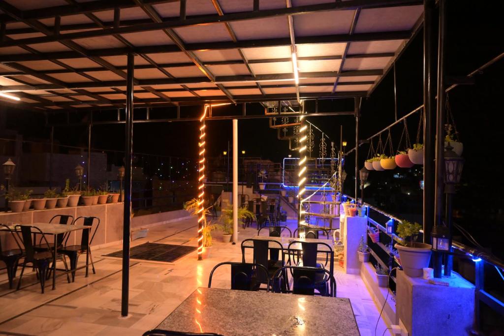 焦特布尔MOON NIGHT GUEST HOUSE的屋顶庭院在晚上配有桌椅