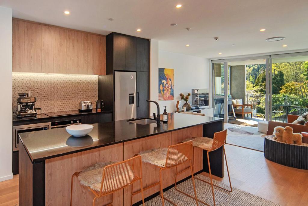 a kitchen with a counter and chairs in a room at Malthouse Lane City Apartment 4 in Nelson