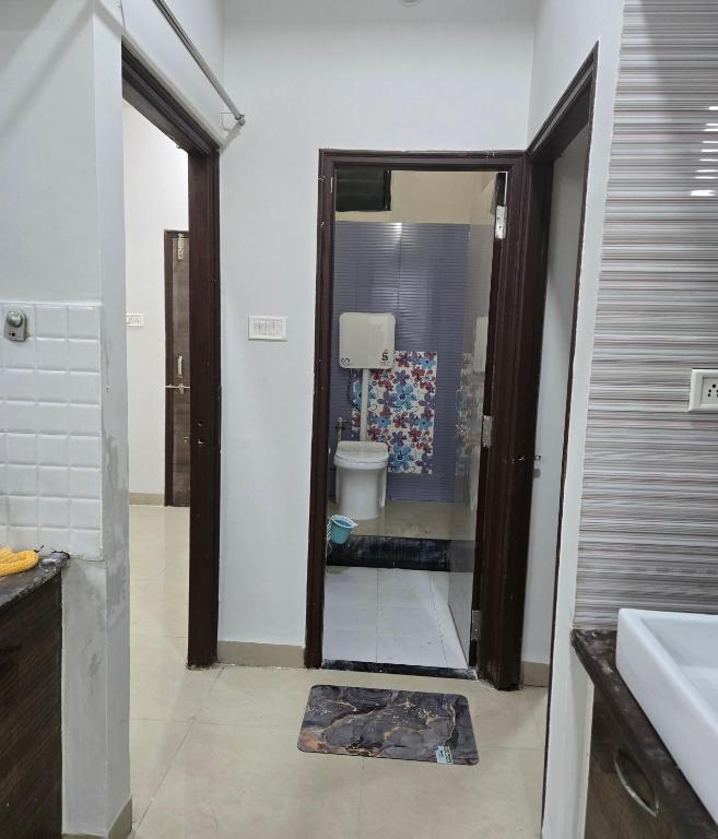 a bathroom with a toilet and a sink and a mirror at Satyabhama Home Stay - Opel - Two BHK in Indore