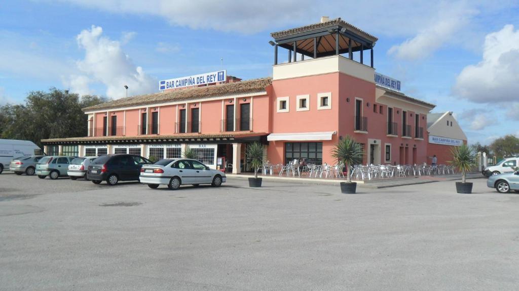 a large building with cars parked in a parking lot at Hotel Restaurante Campiña Del Rey in Villanueva del Rey