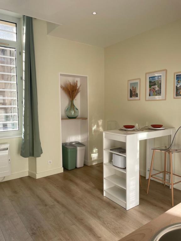 - un salon avec une table blanche et un bureau dans l'établissement Hypnos-Hébergement champenois, à Châlons-en-Champagne