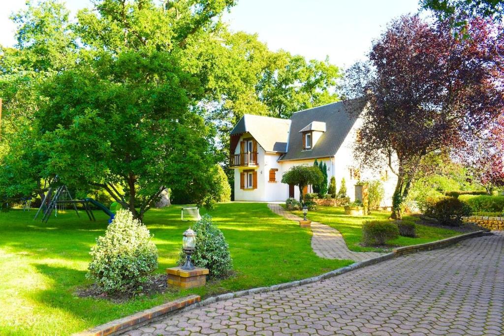 ein Haus mit Garten und gemauerter Auffahrt in der Unterkunft Charmante Maison de Ferrières in Ferrières-Haut-Clocher