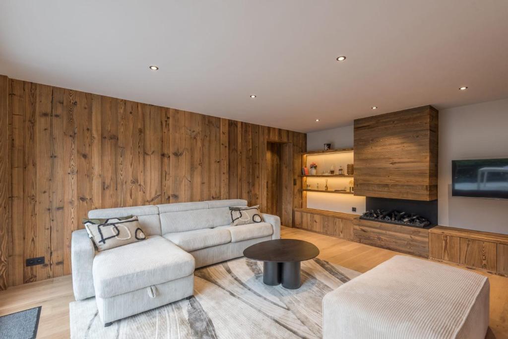 un salon avec un canapé et une table dans l'établissement Le Refuge contemporain - Welkeys, à Megève