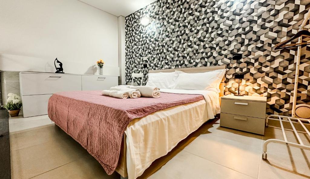 a bedroom with a bed with two towels on it at Loft Stadio - Parking, Gym & Comfort in Turin