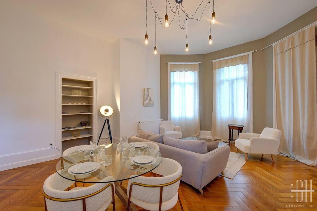 un salon avec une table en verre et des chaises dans l'établissement Le Wilson - Proche Centre Ville, à Tours