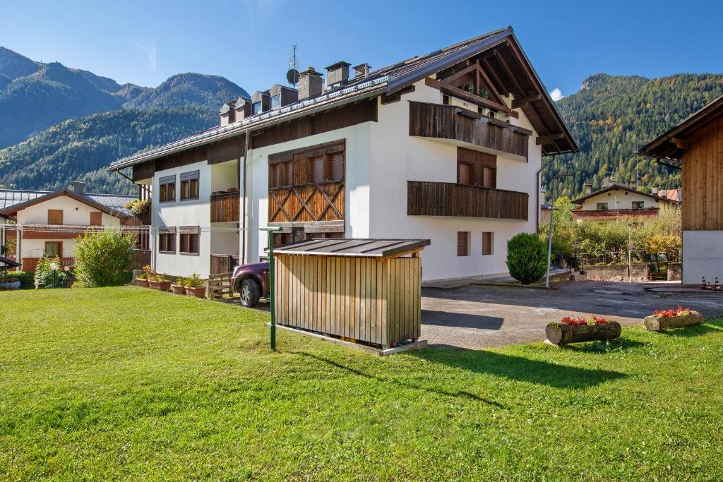 a house with a grass yard in front of it at Appartamento Privato Nelle Dolomiti in Vodo Cadore