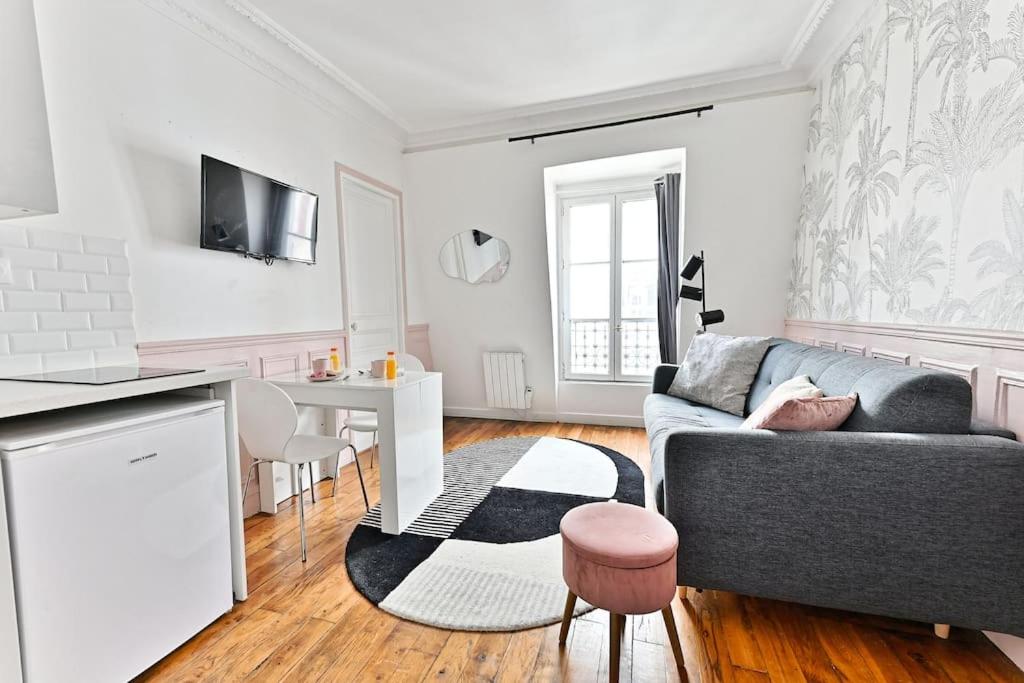 un salon avec un canapé et une table dans l'établissement Magnifique Appartement Rose à #GareMontparnasse, à Paris