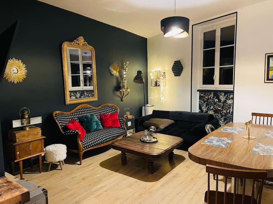 un salon avec un canapé et une table dans l'établissement La petite maison du chineur, à Vincelles