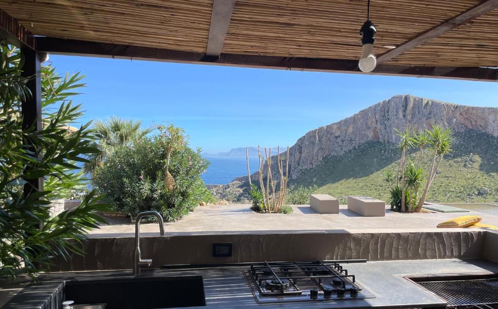 a kitchen with a sink and a view of the ocean at QUIETE e MARE in San Vito lo Capo