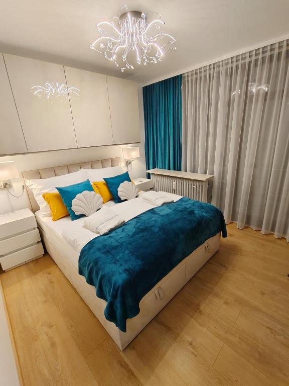 a bedroom with a large bed with a blue blanket at Appartement AquaQuelle in Bad Füssing