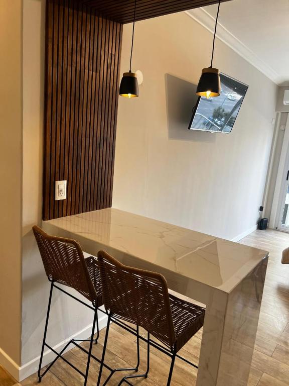 a dining room table with two chairs and two lights at Relax Guemes in Mar del Plata