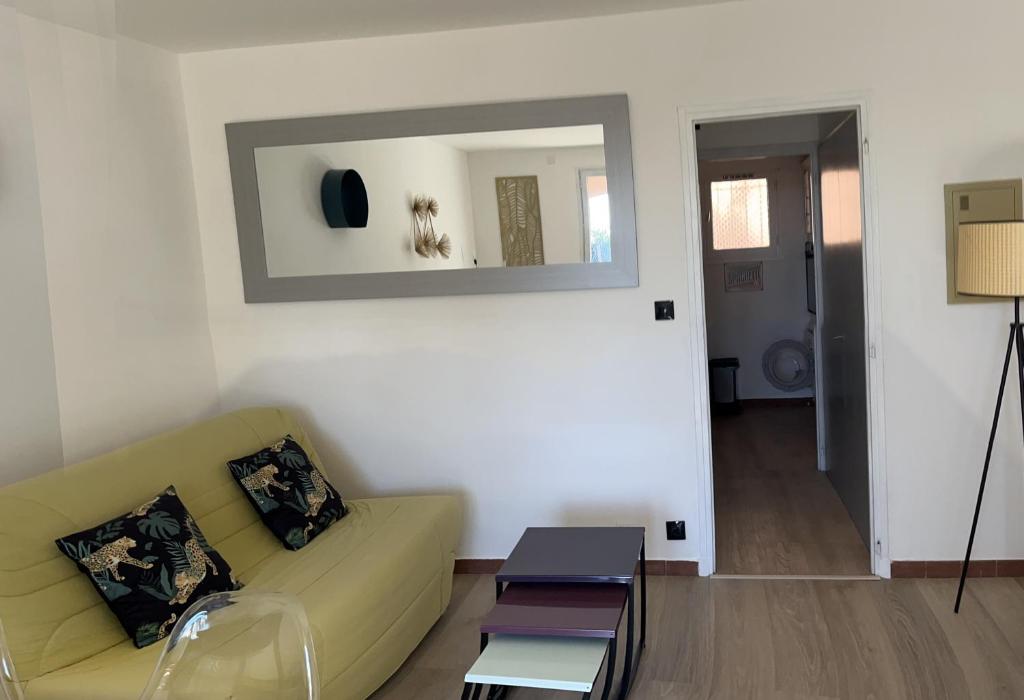 un salon avec un canapé et un miroir dans l'établissement Résidence Cap de l esterel, à Hyères