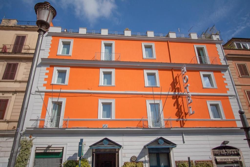 un edificio naranja al lado de una calle en Hotel Laurentia, en Roma