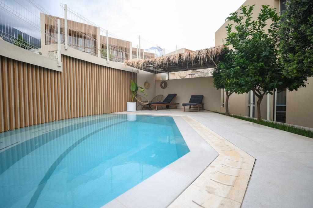 a swimming pool next to a building at Green Coast Resort V94 in Palasë