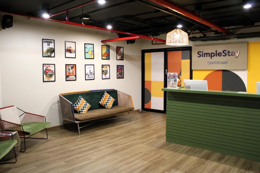 A compact, brightly styled reception lounge with a front desk and seating.