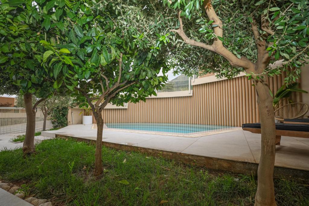 a row of trees next to a swimming pool at Green Coast Resort V94 in Palasë