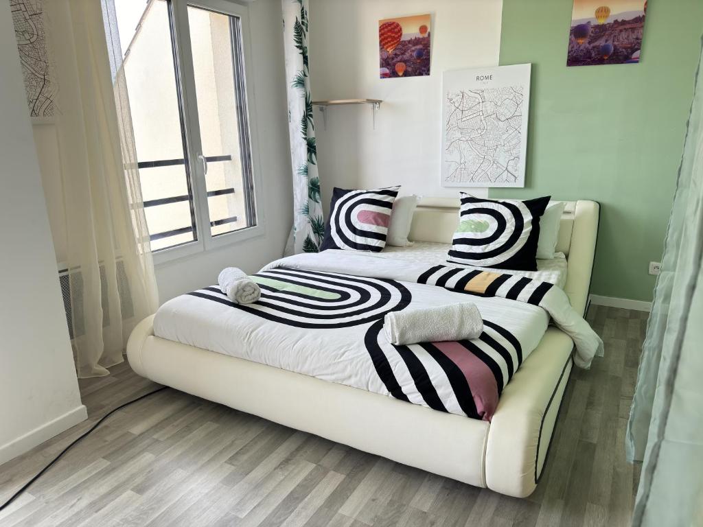 une chambre avec un lit avec des oreillers noirs et blancs dans l'établissement Chambre à Antony proche Orly aéroport, à Antony