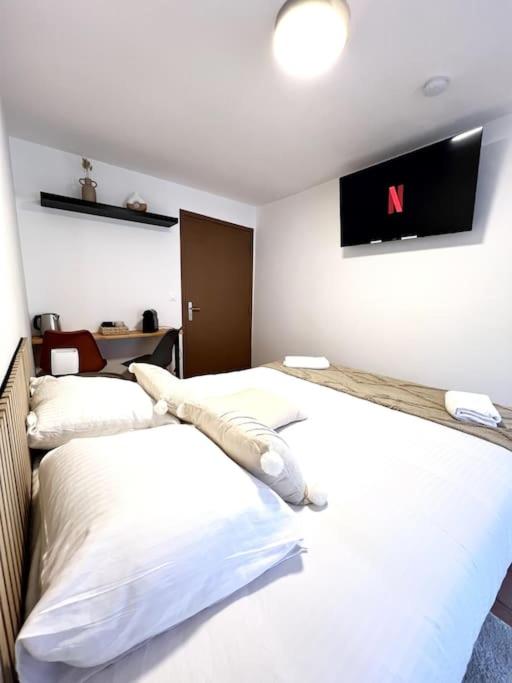 Cette chambre comprend 2 lits et une télévision murale. dans l'établissement Les chambres de la bastide - 303, à Carcassonne