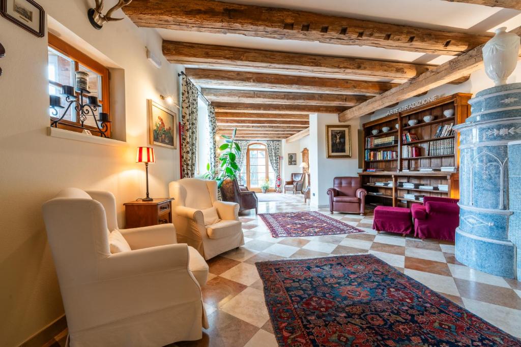 salon z białymi krzesłami i kamiennym filarem w obiekcie Hotel Relais Vecchio Maso w Trydencie