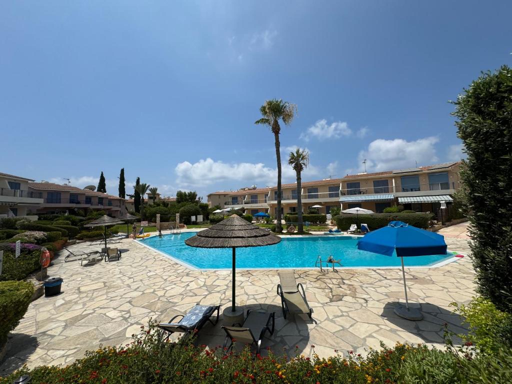 a swimming pool with chairs and umbrellas in a resort at Beautiful 1-bd Ap near the beach historic places in Paphos