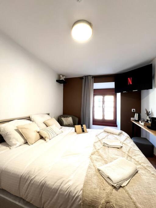 une chambre avec un grand lit blanc dans une pièce dans l'établissement Les chambres de la bastide - 304, à Carcassonne