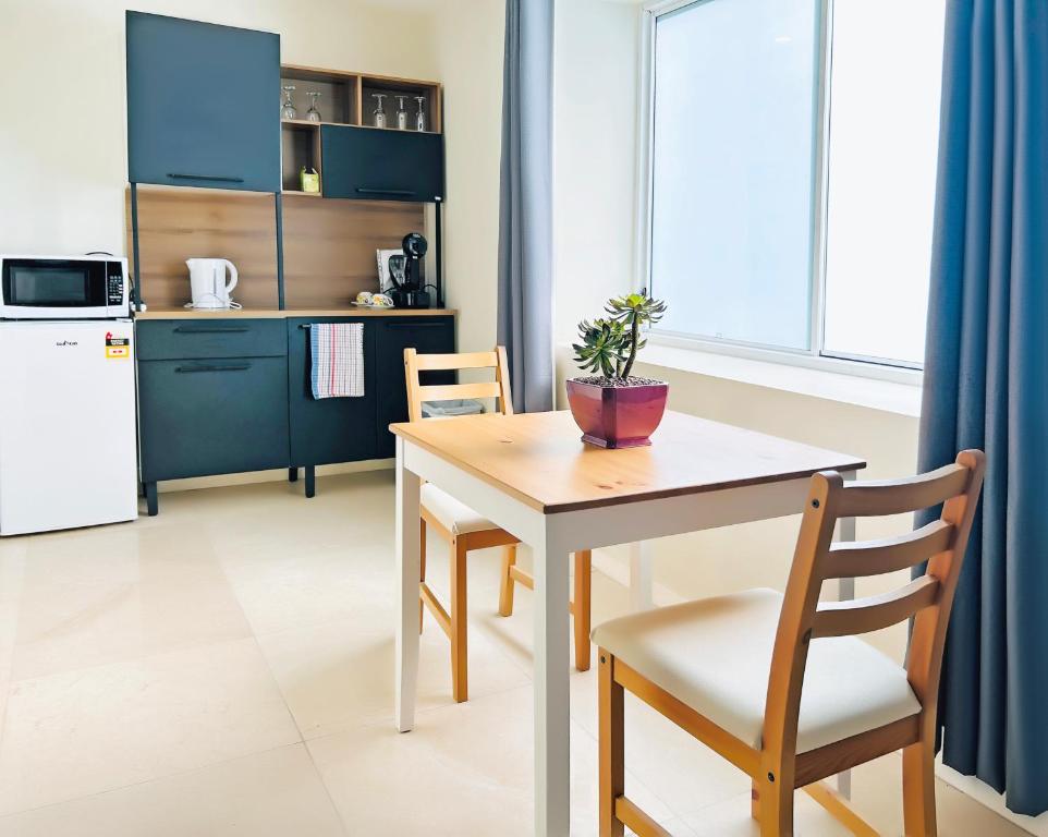 シドニーにあるKozyGuru Summer Hill 1 Bed TownHouseのテーブルと椅子のあるキッチンとダイニングルーム