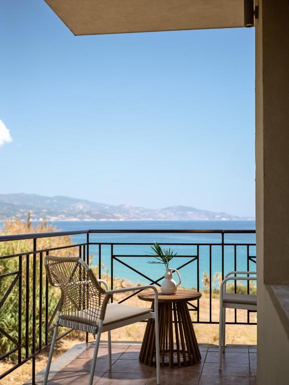 a balcony with a table and chairs and a view of the ocean at Rosa Sea Front Maisonette in Alikanas
