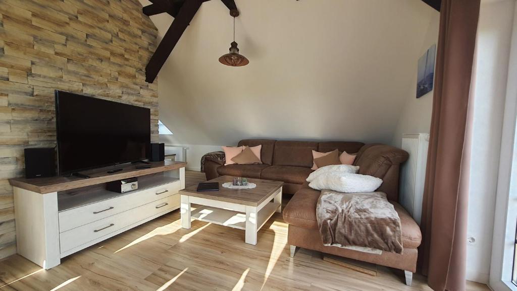 a living room with a couch and a flat screen tv at 5 Sterne Ferienwohnung Dewichow mit Wasserblick & WLAN in Dewichow