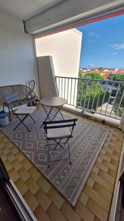 un balcon avec une table et des chaises sur un balcon dans l'établissement Le Corail Grand studio Vue mer avec loggia - Plage et port à 5 min à pied - parking privatif - Draps et ménage inclus, à Saint-Cyprien