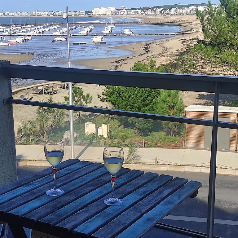 - deux verres de vin assis sur une table sur un balcon dans l'établissement Le Studio Galliéni, face mer, vous accueille en été comme en hiver!, à Pornichet