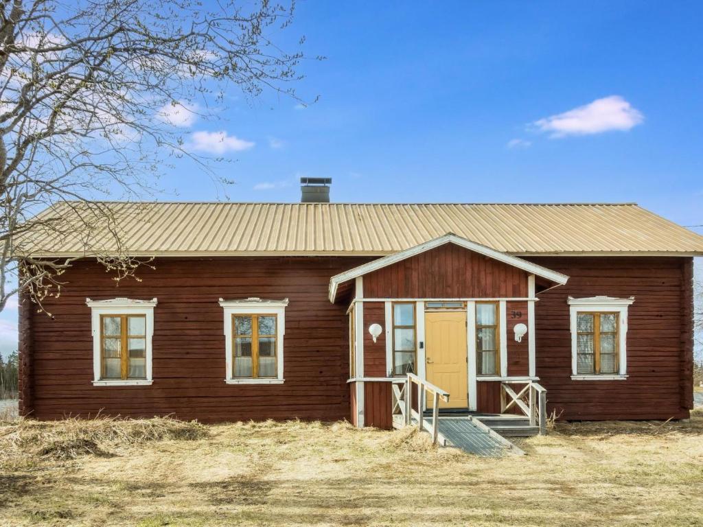 a small wooden house with a yellow door at Holiday Home Ounasmosku by Interhome in Tepasto