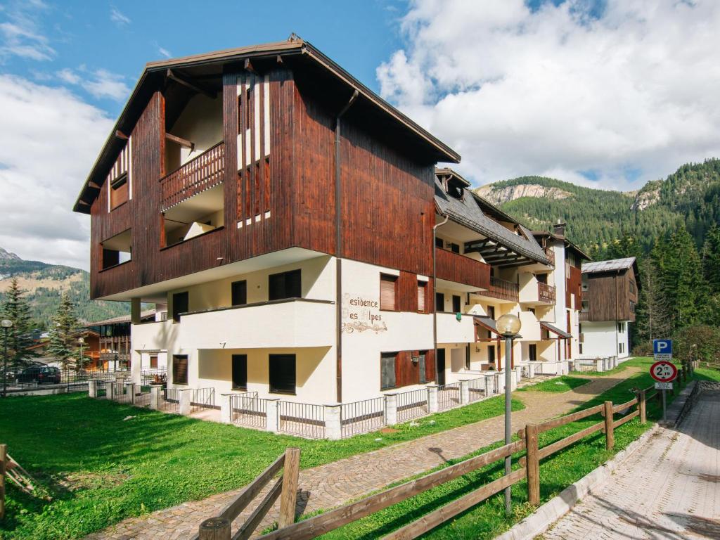 a building in the mountains with a wooden roof at Apartment Apt 18 by Interhome in Campitello di Fassa