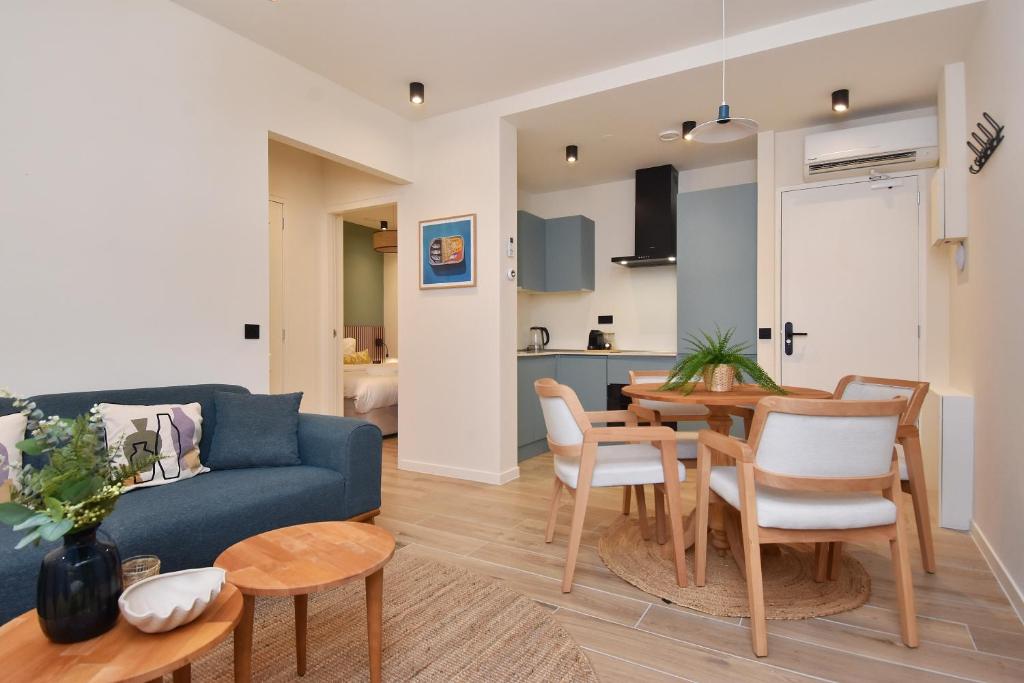 a living room with a blue couch and a table and chairs at Curated apartment near Scheveningen beach in Scheveningen
