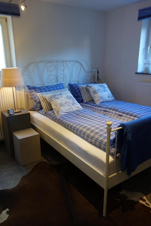 a bed with blue sheets and pillows in a bedroom at Chiemgau-ROOM, helles Souterrain, eigene Terrasse in Riedering