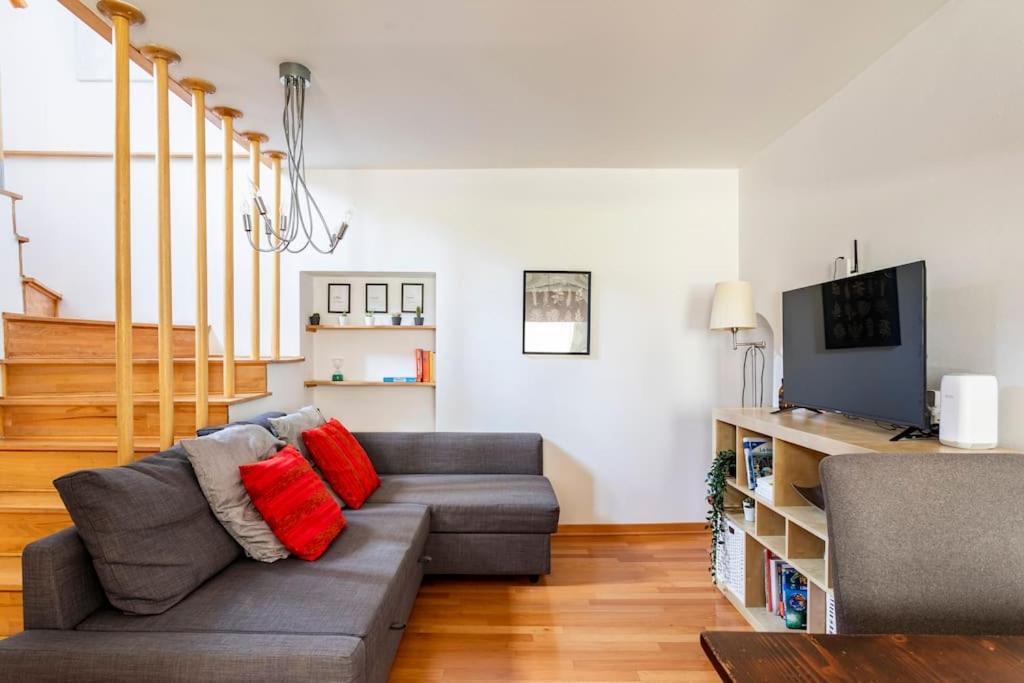 ein Wohnzimmer mit Sofa und Fernseher in der Unterkunft Terratetto in centro con parcheggio in Udine