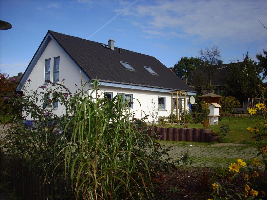 ein weißes Haus mit schwarzem Dach in der Unterkunft Ferienwohnung Familie Hübner in Lübeck