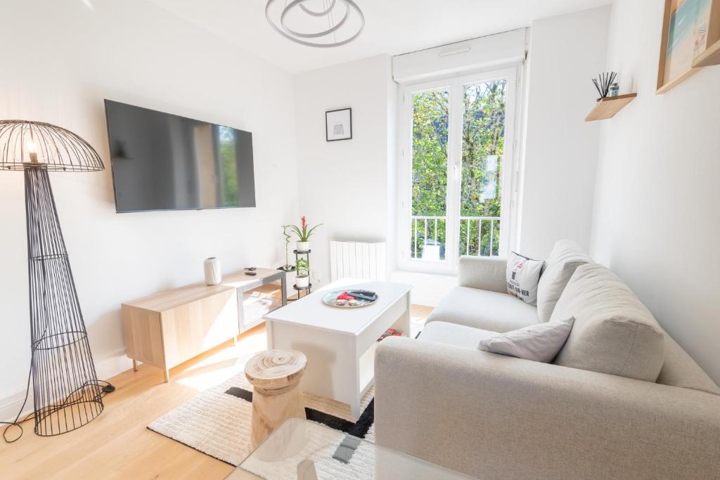 un salon blanc avec un canapé et une table dans l'établissement PREMIUM T2 neuf 2ème étage ultra Centre Lorient par Groom, à Lorient