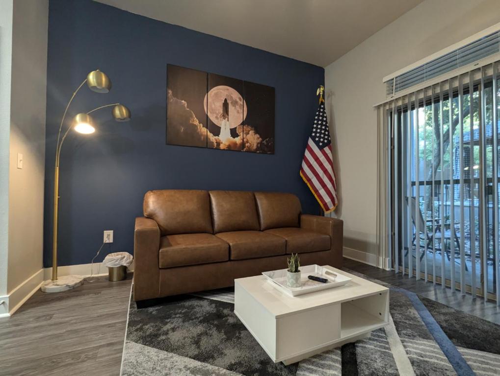 a living room with a couch and an american flag at The Apollo - Lux 1-Bed Apartment near Space Center in Houston