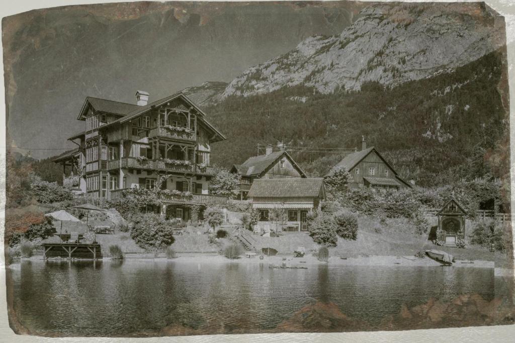 a black and white photo of a house on a lake at Haus Paradies am See in Grundlsee