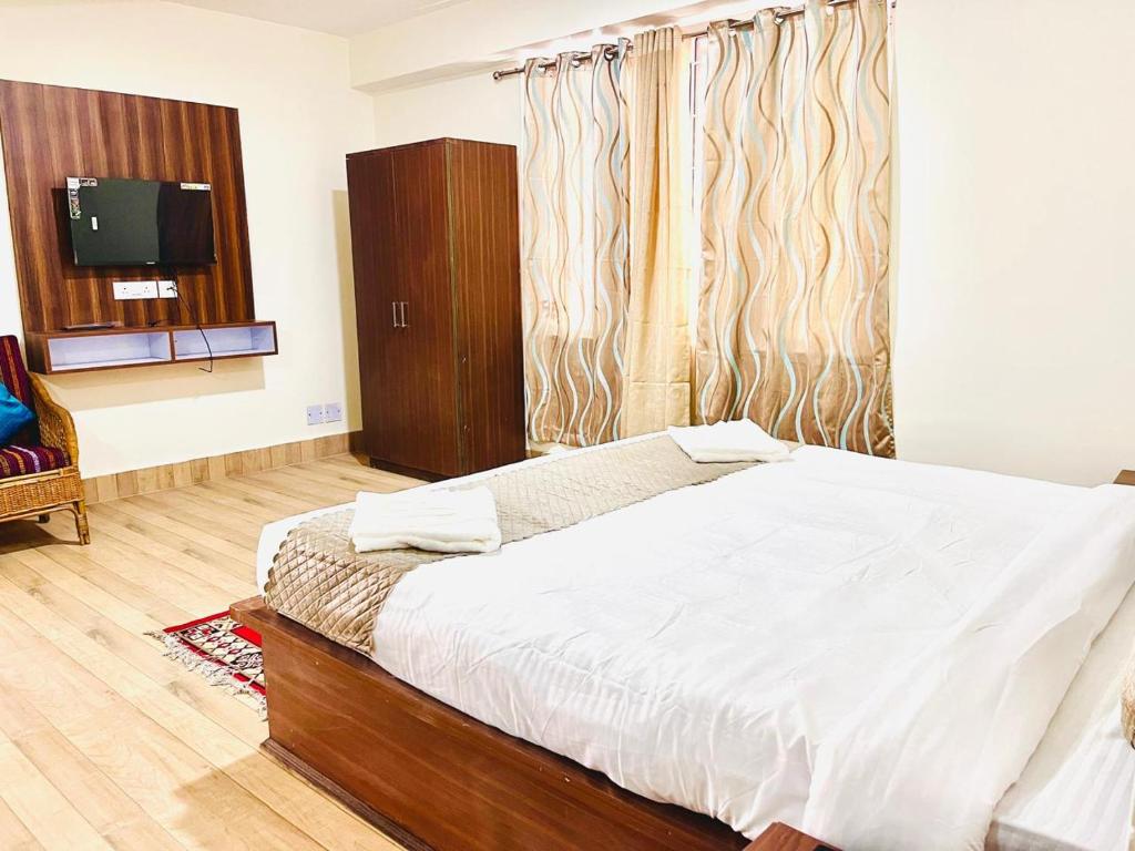 佩林Hotel Swagat的房间里有一张床和一台电视的卧室