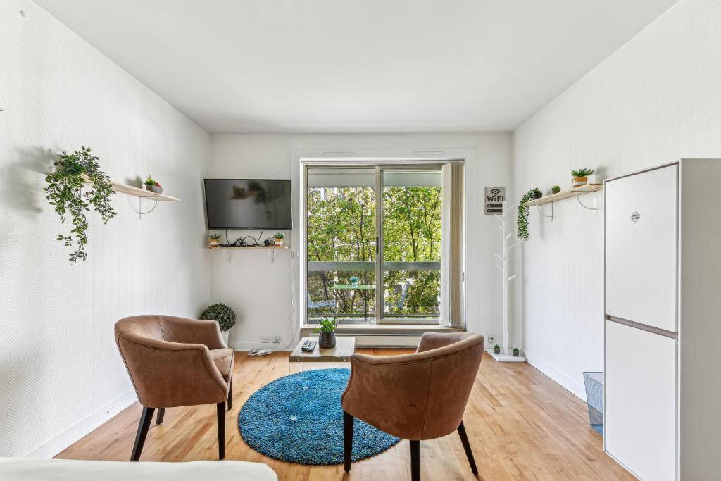 un salon avec deux chaises et une table dans l'établissement Chic studio Champs-élysées, à Paris
