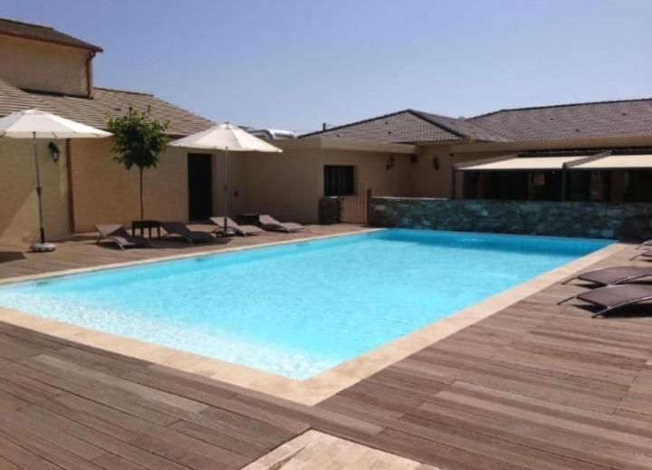 une grande piscine avec chaises et parasols dans l'établissement Soleil, Piscine, Parking et Bienvenue à Sisco, à Sisco
