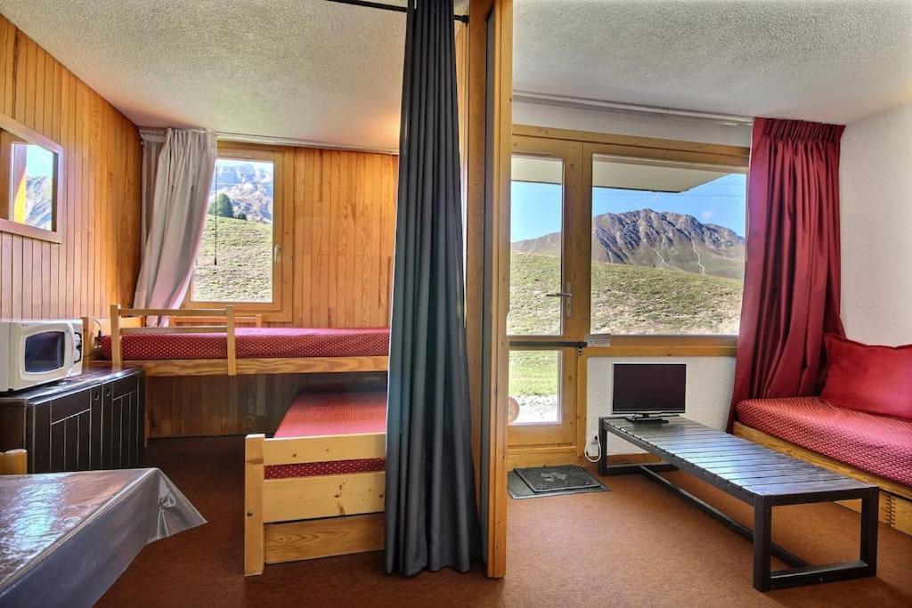 Cette chambre comprend un lit et un bureau avec un moniteur. dans l'établissement La Plagne Appartement 5 couchages Skis aux pieds, à La Plagne Tarentaise