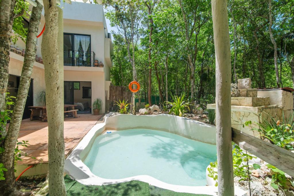 a pool in the backyard of a house with trees at 1-BR Gem Apartment Villa Sofia in Chemuyil
