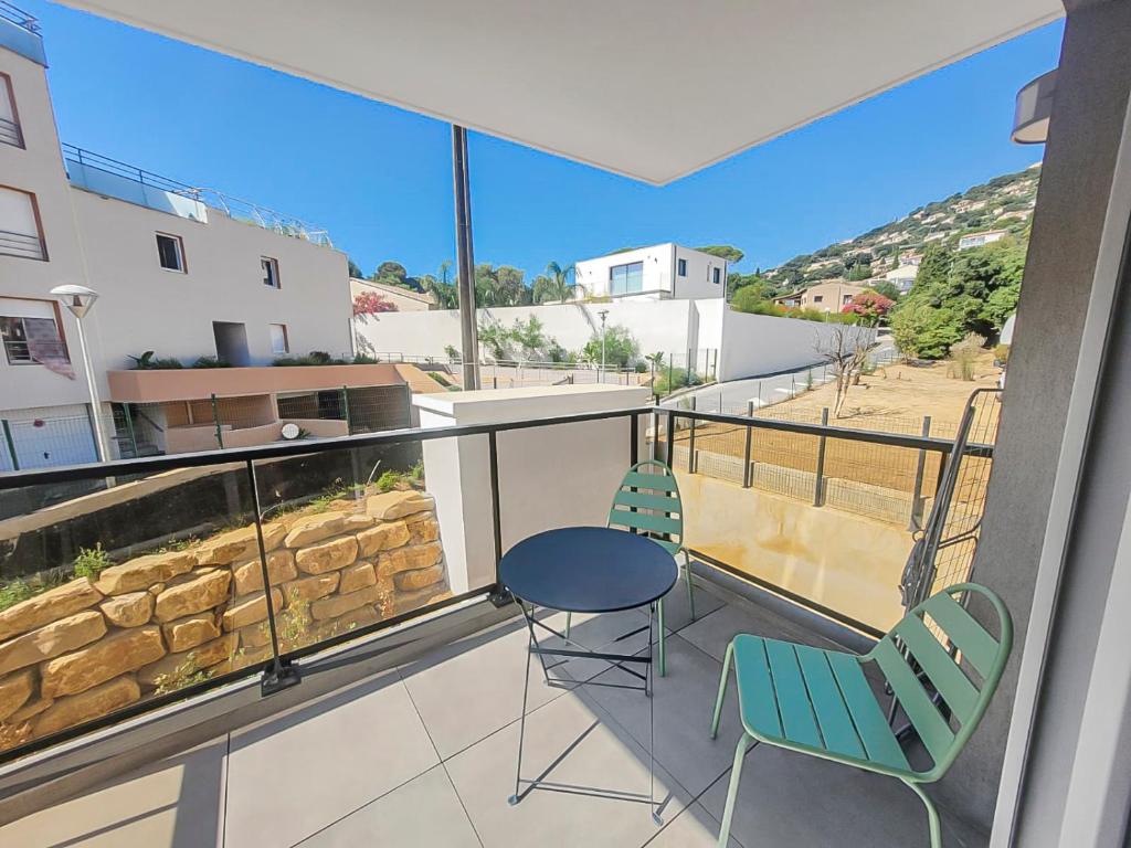 un balcon avec deux chaises et une table dans l'établissement Séjour Central Cavalaire sur Mer - Élégance & Confort, à Cavalaire-sur-Mer